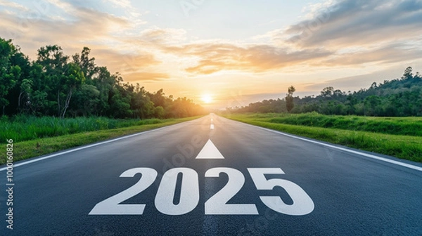 Obraz A wide, empty road stretching into the distance, with the bold numbers "2025" painted on the asphalt, a large arrow pointing to the horizon where a sunrise breaks through the cloud
