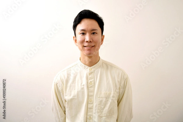 Obraz カメラ目線の笑顔の若い私服のアジア人男性