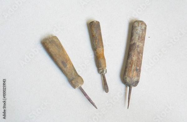 Fototapeta Ancient tools for making holes and sewing on gray background