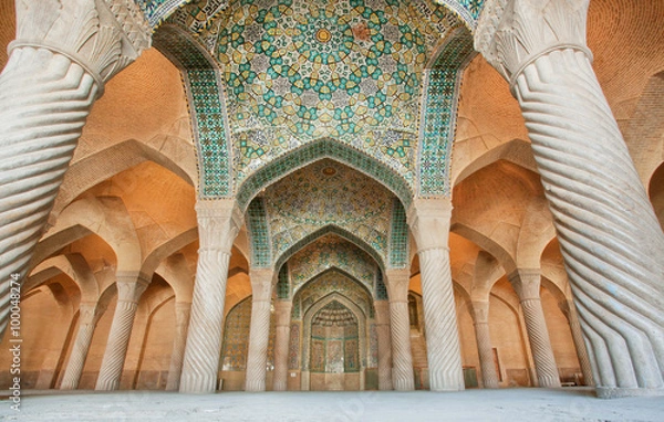 Fototapeta Persian patterns on the ceiling of mosque with columns and artworks, Iran