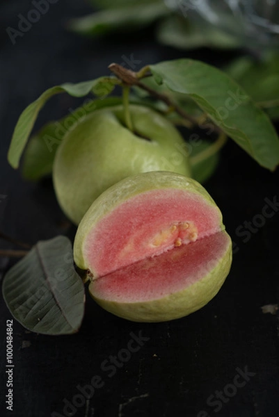 Obraz Pink and green guava slice with leaf on dark table
