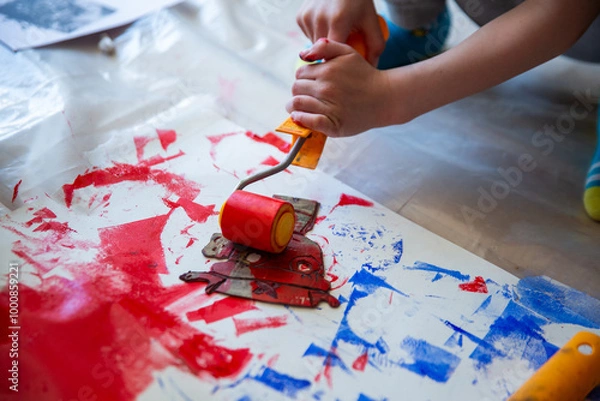 Fototapeta Children creating lino cut prints on paper using rollers, paint, and spoons in an art workshop. Creativity, craft techniques, and artistic expression, educational and creative stock imagery.