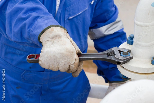 Fototapeta Close-up image of human hand fixing and stop leak flange by wrench in oil and gas process