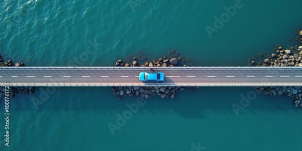 Fototapeta A passenger car drives over a connecting road over a bridge over water on the coast, coastal road by the sea