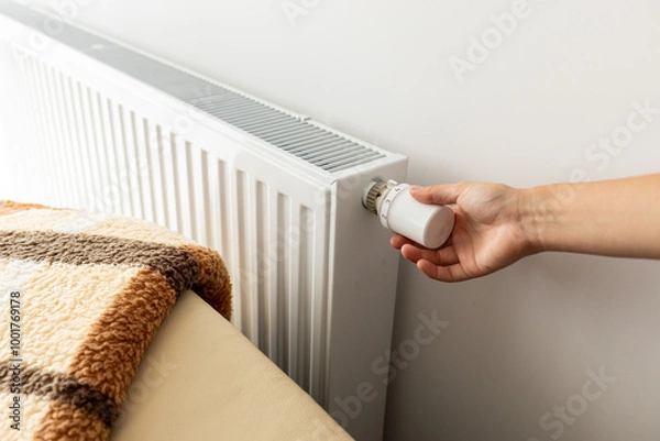 Fototapeta modern radiator for heating in the apartment with power regulators. ideal for those costs of heating and utilities in winter,  person regulates the level of heat