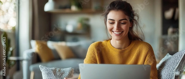 Fototapeta woman smiling while reviewing her work on laptop in cozy living room. warm atmosphere and her joyful expression create sense of comfort and productivity