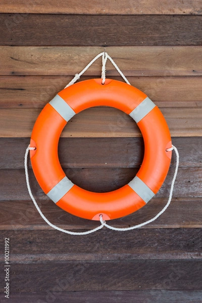 Fototapeta Оrange lifebuoy on wooden wall