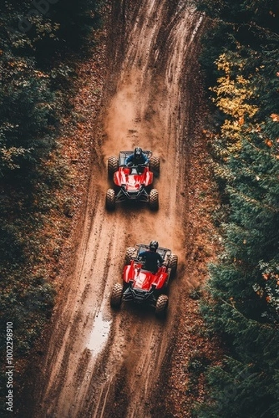 Fototapeta Muddy off-road race with two ATV riders driving through a dense forest.