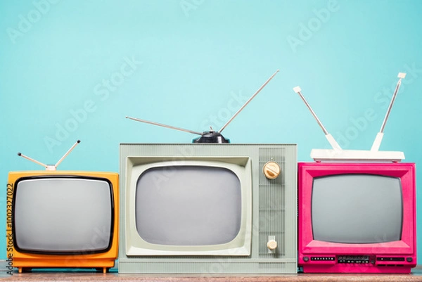 Obraz Retro TVs set on table front mint blue background. Vintage old style filtered photo