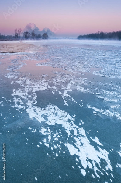 Obraz Smoking chimneys over a misty and freezing river during dusk