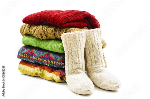 Obraz Wool socks and stack of various sweaters. Winter style. Isolated on white background 