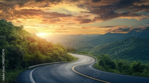 Fototapeta A winding road with a beautiful sunset in the background