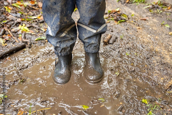 Fototapeta Child in welly boots, jump, jumping in mud.
