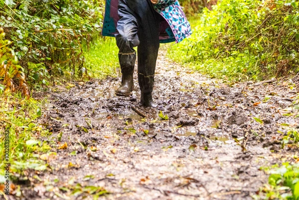 Fototapeta Child in welly boots, jump, jumping in mud.