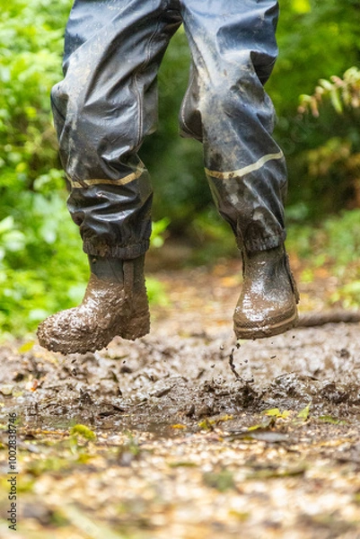 Fototapeta Child in welly boots, jump, jumping in mud.