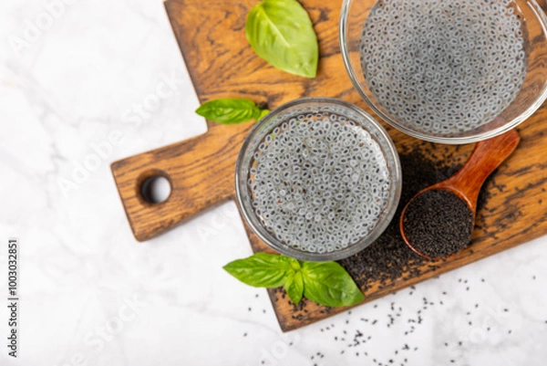 Fototapeta Basil seeds on textured wooden background. Close-up. Superfood. Ocimum basilicum. Organic basil seeds. selasih. Space for text. Copy space.