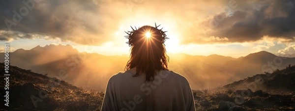 Obraz Jesus Christ with a crown of thorns on his head, seen from behind, looking at the sun in a mountainous landscape