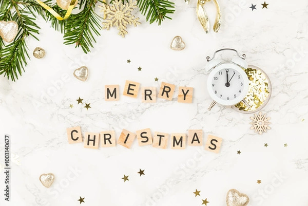 Obraz Top view background: Christmas tree branches and an inscription Merry Christmas from wooden blocks on white marble decorated for x-mas. New Year or Christmas Greating card. Clock indicating 00:00