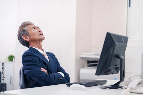 Fototapeta オフィスで腕を組んで悩む中年の上司