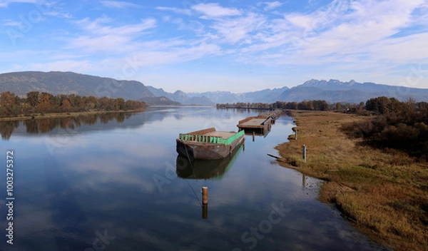 Obraz River full of  reflections of clouds and moored barges