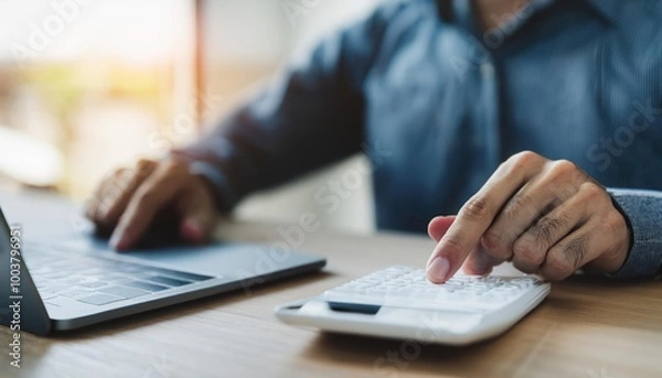 Fototapeta close up young man hand press on calculator to check and summary expense of home loan mortgage 
