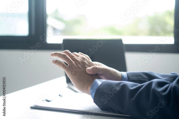 Fototapeta Businessman in office Using a laptop to work so hard that it hurts his wrists, hand massage physiotherapy other side is sore and numb, Guillain-Barre Syndrome, side effect of vaccination