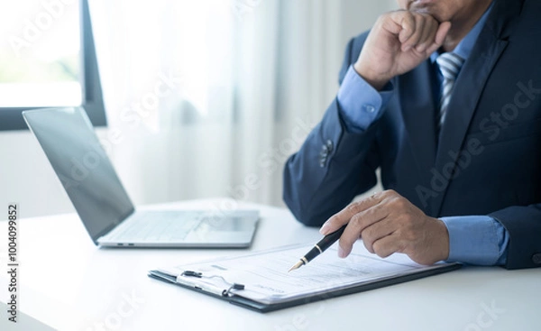 Fototapeta Executive CEO businessman checking job applicant documents resumes, interviews, and signing to approve the contract in the office room