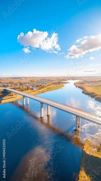 Obraz Stunning Drone View of a Bridge Over a Wide River Connecting Two Vibrant Towns