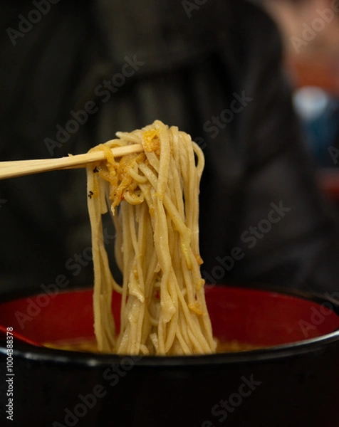 Fototapeta Ramen noodles picked up by chopticks.