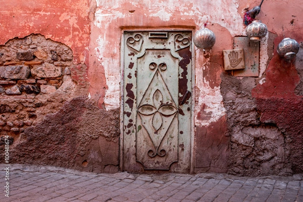 Obraz Zielone drzwi w czerwonej ścianie ze srebrnymi latarniami na ulicy w pobliżu Souk w Marrakesz w Maroku.