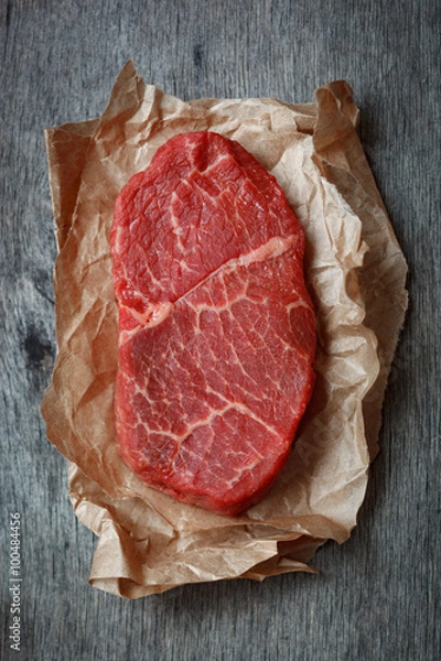 Fototapeta Raw beef steak on a paper