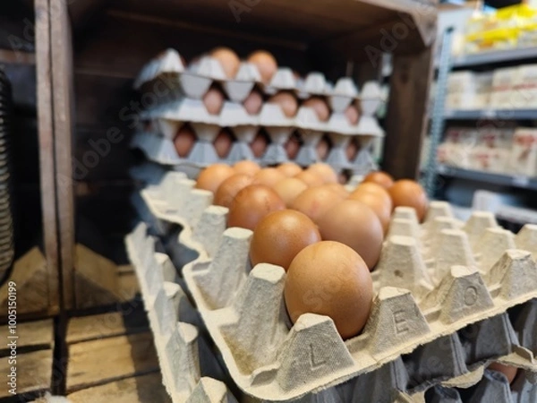 Fototapeta Close up shot of stacked cardboard egg tray boxes with fresh eggs lie on a supermarket shelf to be sold
