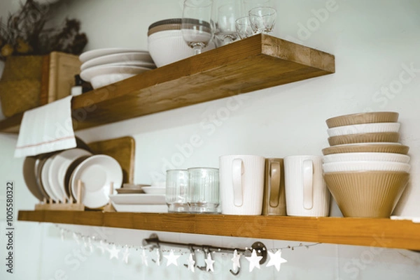 Obraz Wooden shelf with Glass, coffee cup, plate, bowl various cookware and decoration in kitchen. Hanging storage. Organization kitchen room concept