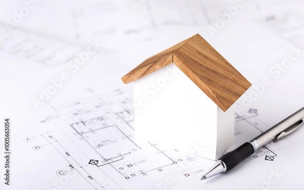 Obraz Concept of building permit application, featuring a house model and construction plans placed on a table, symbolizing the process of planning and approval for home construction