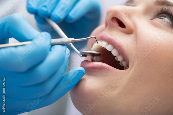 Obraz Dentist examining a patient's teeth in the dentist.