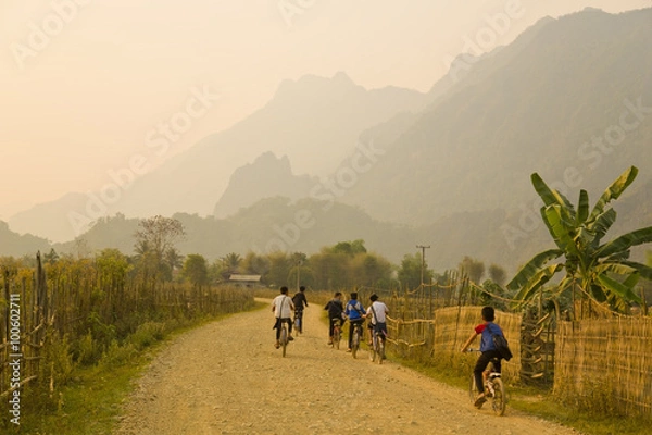 Obraz Children cycling, Sunset at limestone mountains of Vang Vieng, Laos