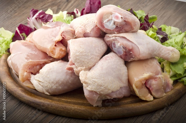 Obraz Fresh skinless chicken thighs and legs on cutting board