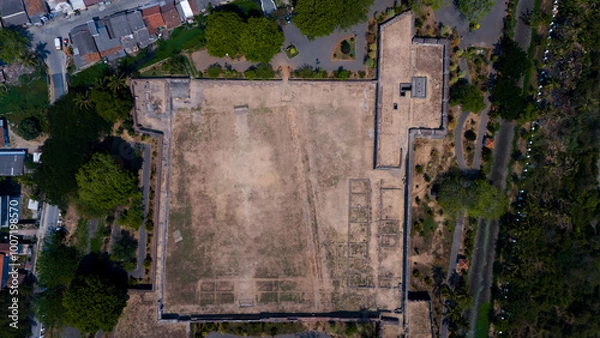 Fototapeta Aerial view of a large fortress surrounded by trees and urban environment, showcasing potential for development and space utilization