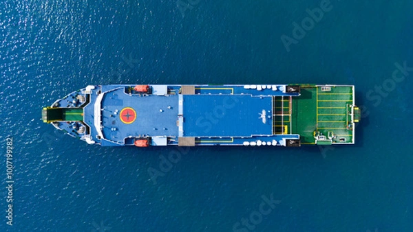 Fototapeta Aerial view of a solitary cargo ship navigating the azure waters, showcasing the scale and isolated beauty of maritime logistics