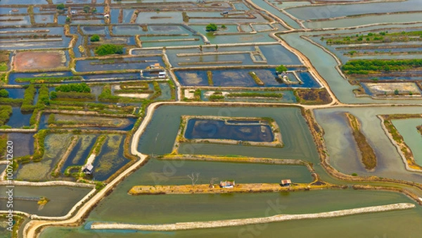 Fototapeta Aerial view showcases the intricate patterns and vibrant hues of salt ponds, revealing nature's palette and human industry's geometry