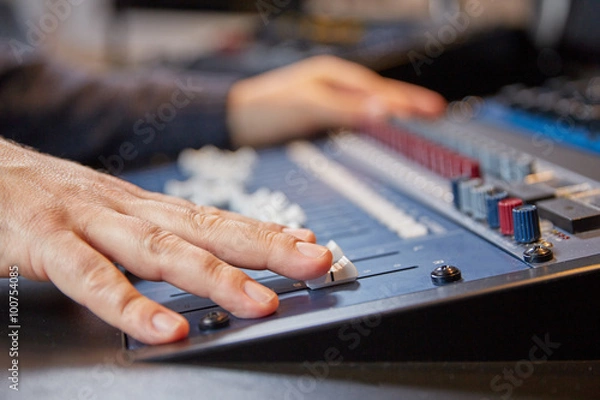 Fototapeta Mixing engineer moving the sliders of audio console