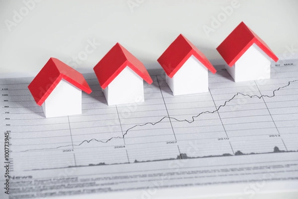 Fototapeta Modele domu na wykresie finansowym przy biurku