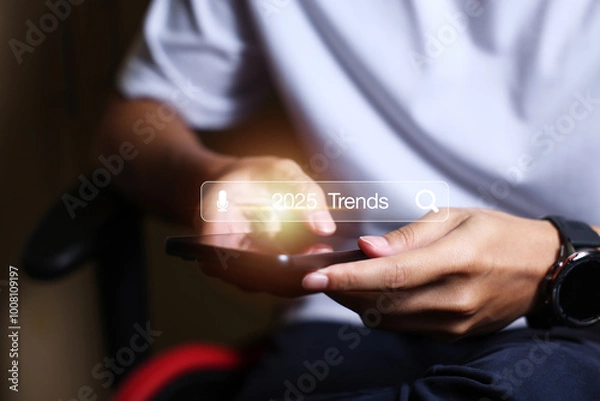 Fototapeta Touching to search engine bar with 2025 trends wording for marketing monitor and business planing in new year concept. Finding information and new ideas for doing business in 2025