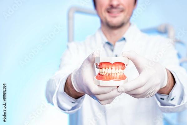 Fototapeta glücklicher zahnarzt präsentiert das gebiss 