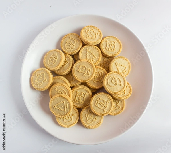 Obraz round cookies with various designs on them, including Christmas themed symbols like trees, snowmen, and other festive characters. vanilla or butter flavored sandwich cookies.