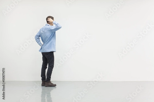 Obraz Man standing in front of a white wall, concept of thinking, making ideas