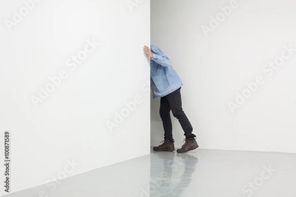 Obraz Man in white room looking behind corner