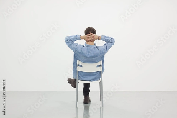 Obraz Man sitting on a chair in white room