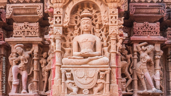 Fototapeta Ornate intricate carving of buddha surrounded by devotees in indian temple, unesco world heritage site, india