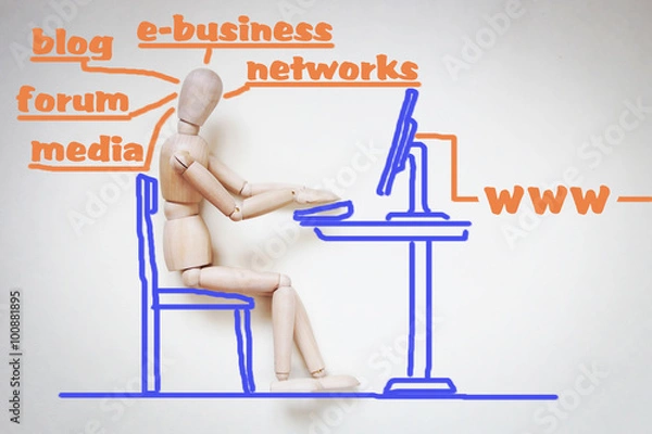 Obraz Man working with his computer in the internet. Abstract image with a wooden puppet